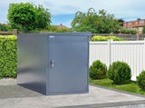 Grey metal bike storage shed / locker in a garden setting with greenery and a white fence.