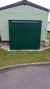 Trojan plus caravan shed storage in green located next to a caravan